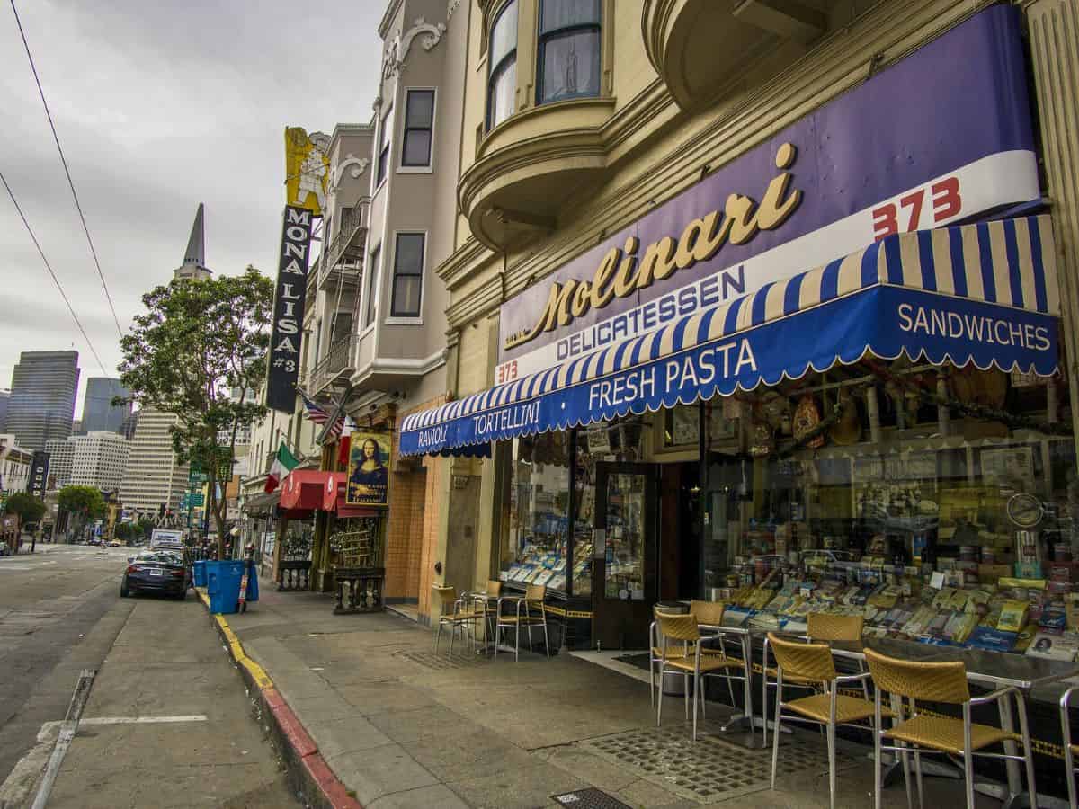 A street in San Francisco's North Beach neighborhood with a storefront and sidewalk cafe.