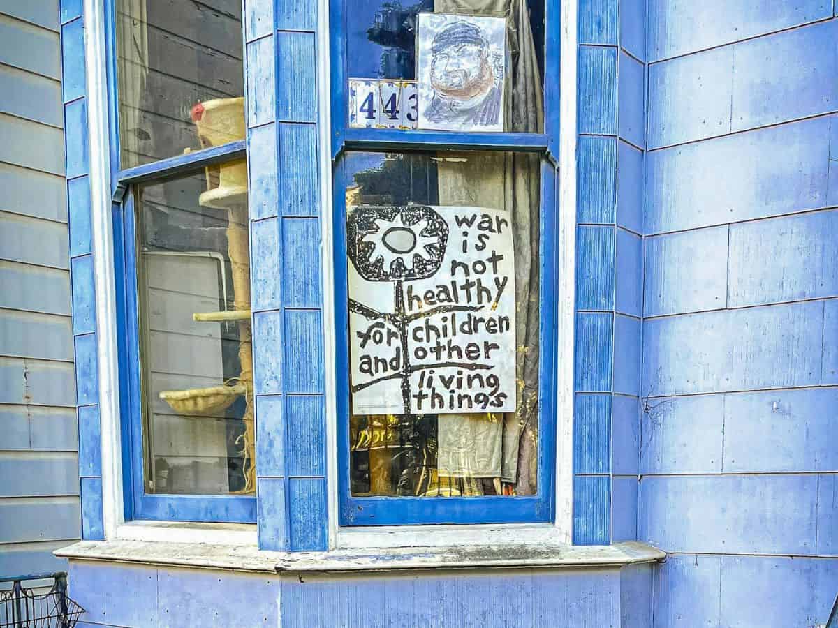 A blue house with a sign in the window.