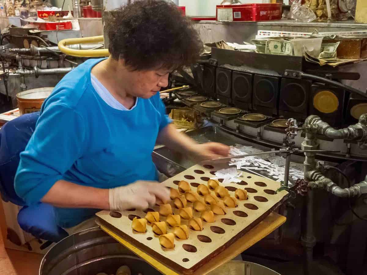 A woman making fortune cookies in a factory in San Francisco's Chinatown.