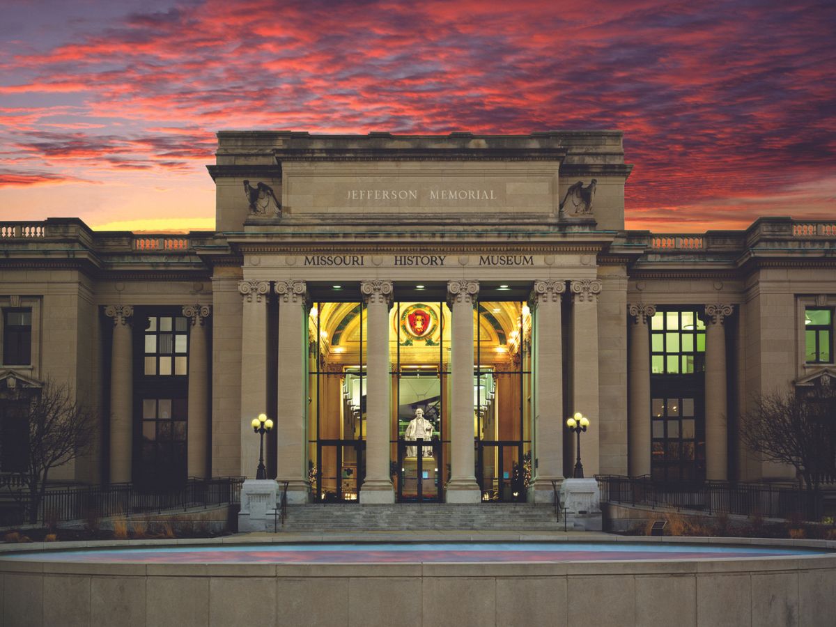 Missouri History Museum in St. Louis with a vibrant sunset in the background.