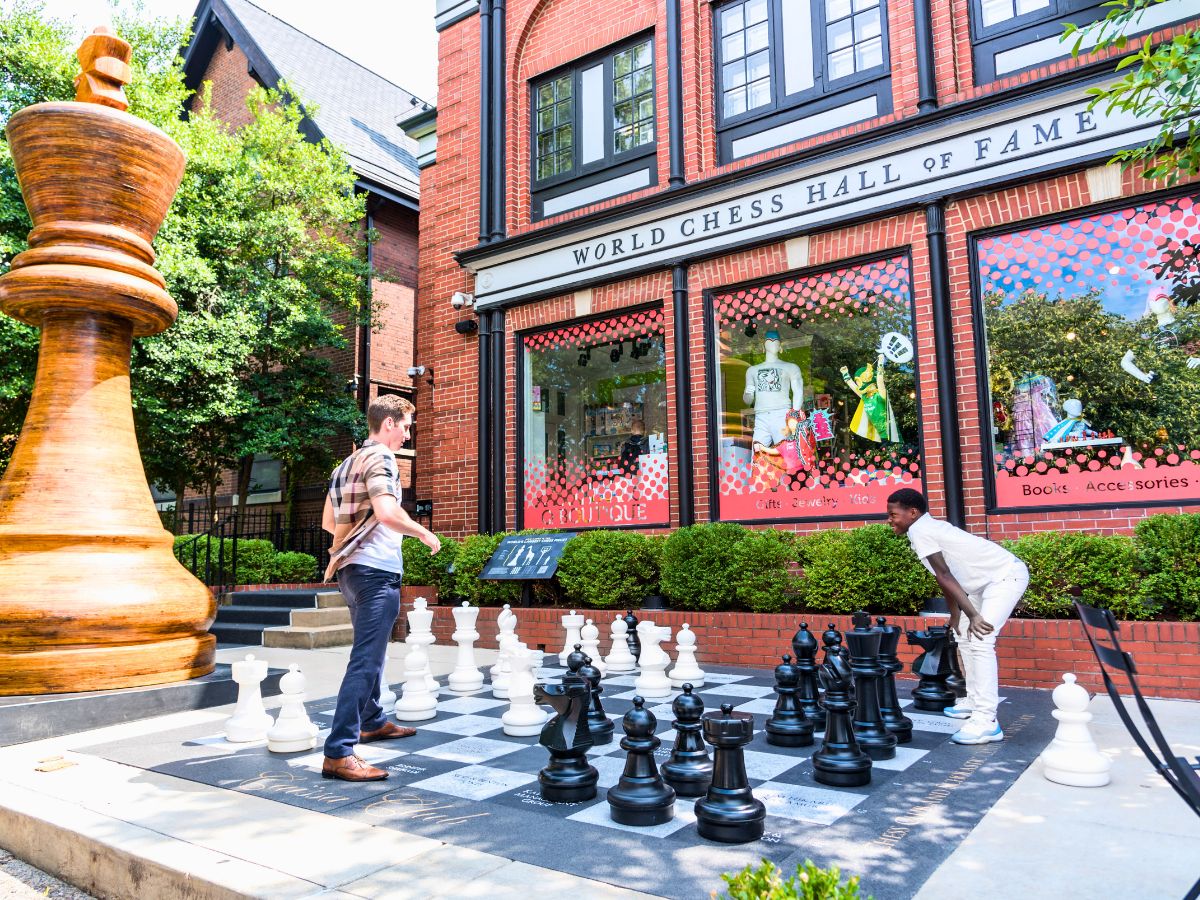 Two individuals playing oversized chess outside the World Chess Hall of Fame in St. Louis.