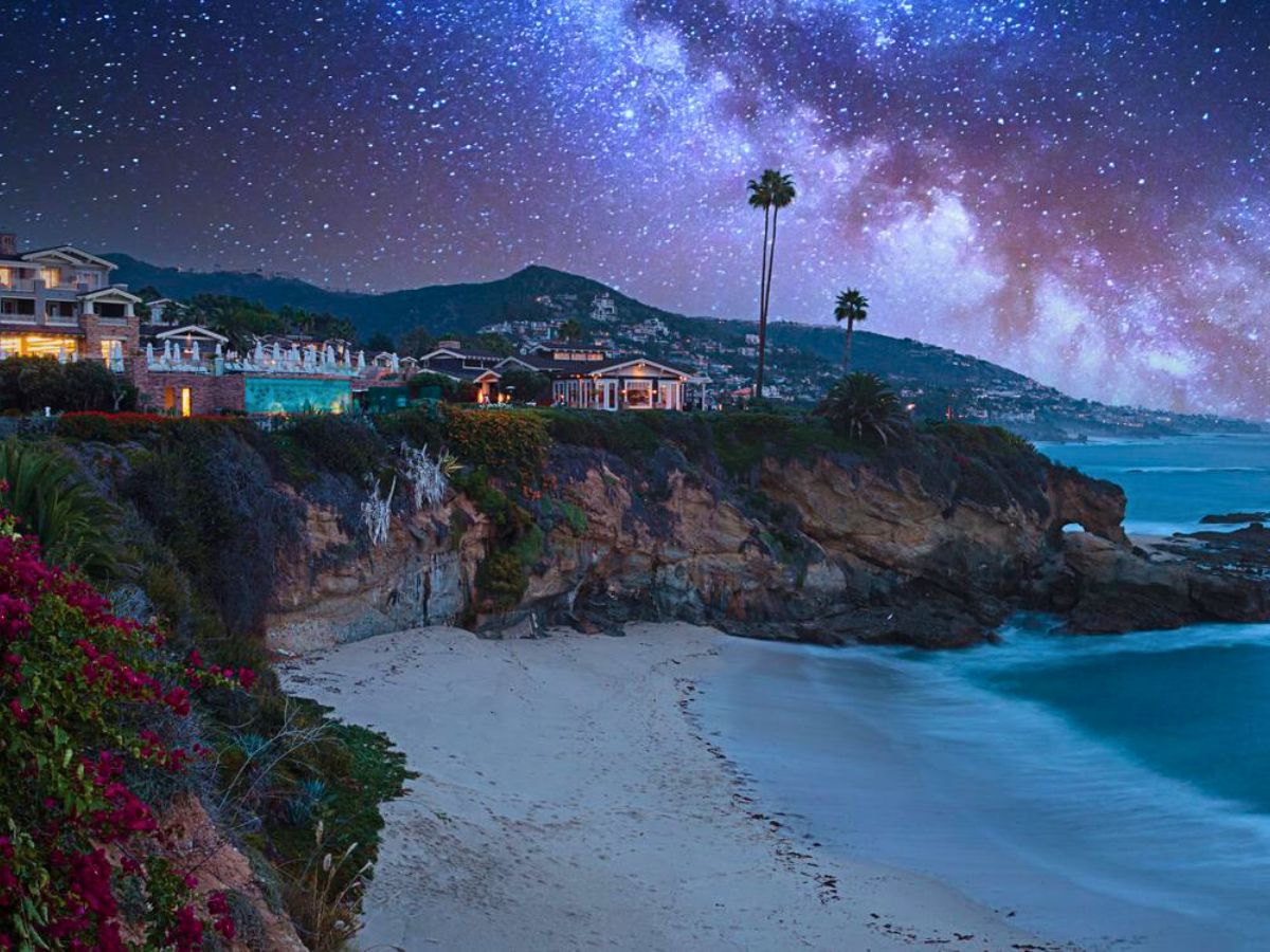 Coastal homes overlooking Laguna Beach under a starry night sky.