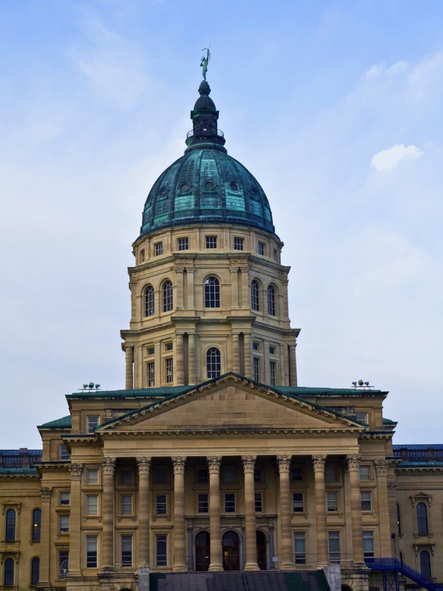 A photo of a large, stately building with a prominent copper dome under a cloudy sky.