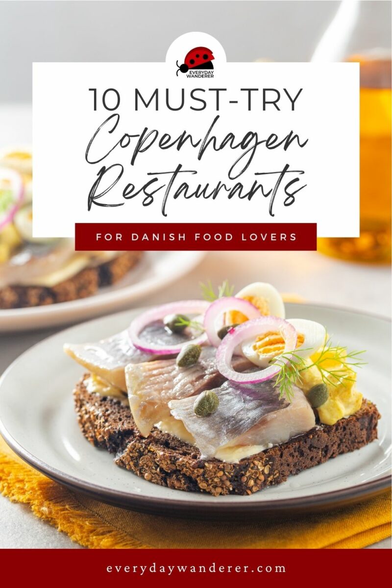 A plate with open-faced sandwiches topped with fish, onions, and capers features in a promotional image for "10 Must-Try Copenhagen Restaurants for Danish Food Lovers" by everydaywanderer.com.