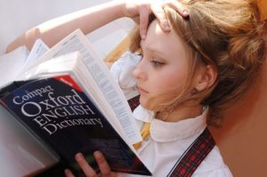 Young girl reading Oxford English dictionary
